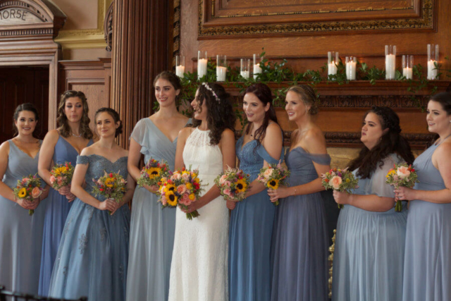 Bride and bridesmaids holding wildflower bouquets.