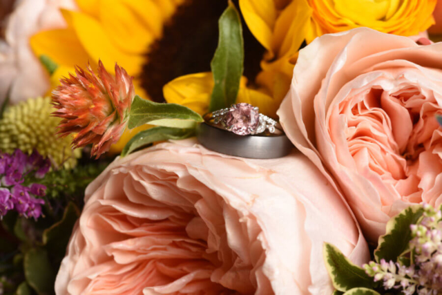 Wedding rings sitting a top a bouquet of wildflowers.